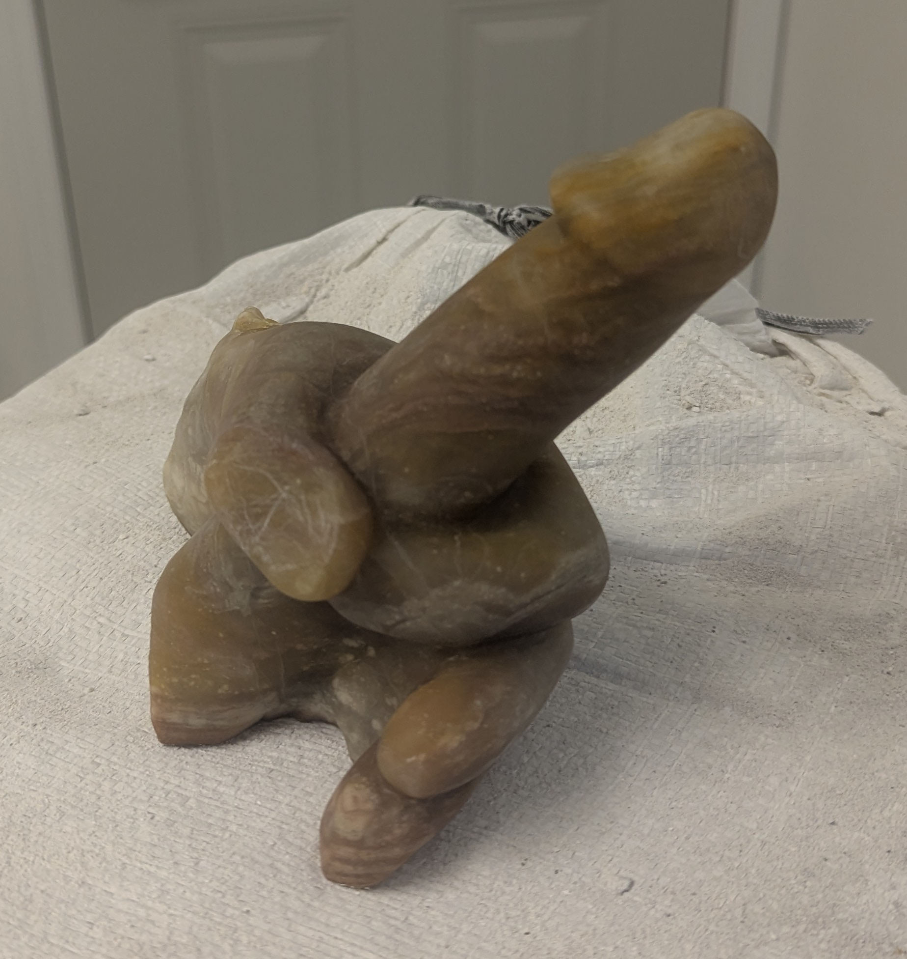 a sculpture made from alabaster featuring an erect penis