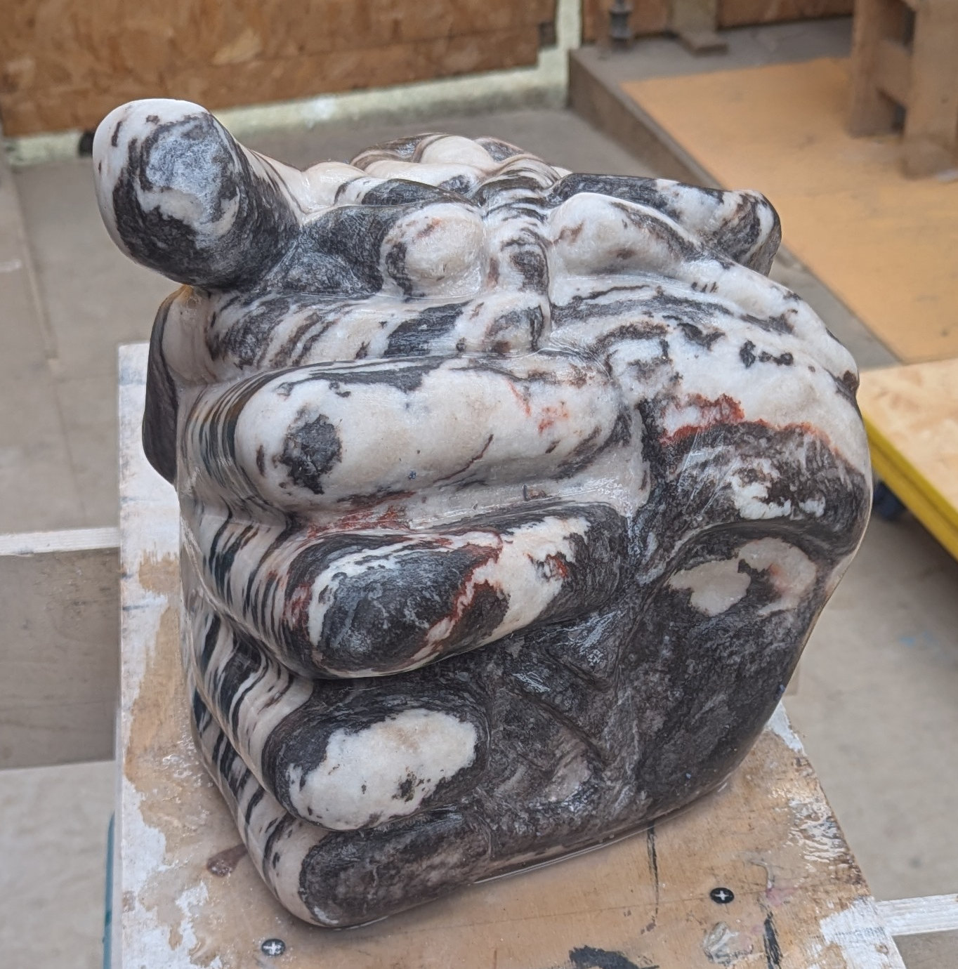 a sculpture depicting a head being held by a hand with brains oozing out of it