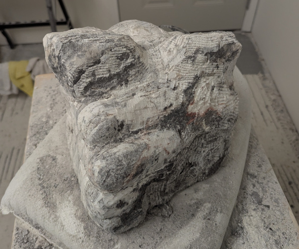 a sculpture depicting a head being held by a hand with brains oozing out of it