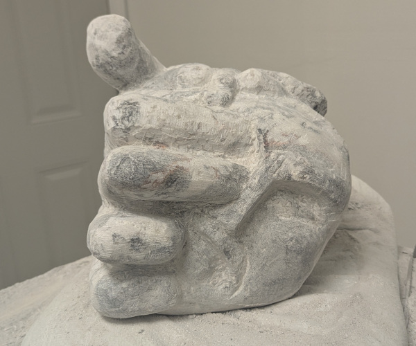 a sculpture depicting a head being held by a hand with brains oozing out of it