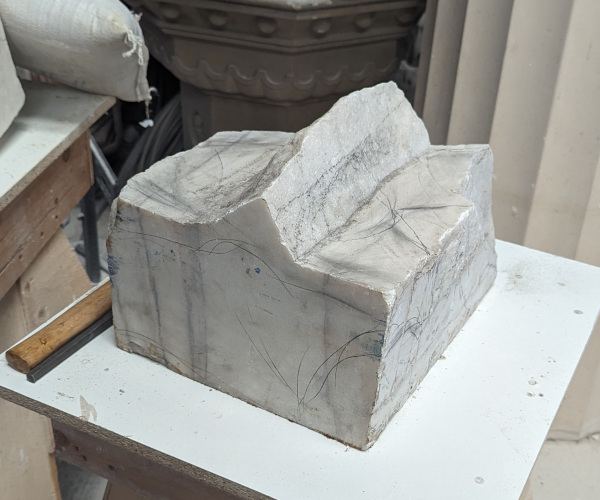 a sculpture made from marble showing a nude male figure