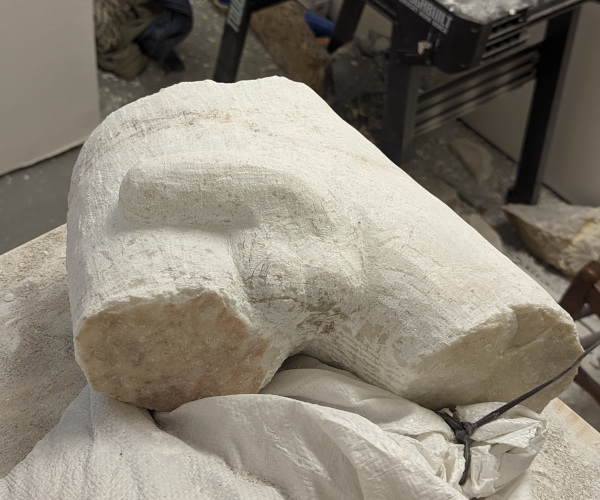 a sculpture made from marble showing a nude male figure